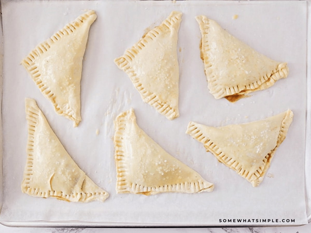 Raw Apple Turnovers on a baking sheet getting ready to go into the oven