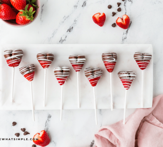 chocolate strawberry heart pops - lined up on a white serving tray