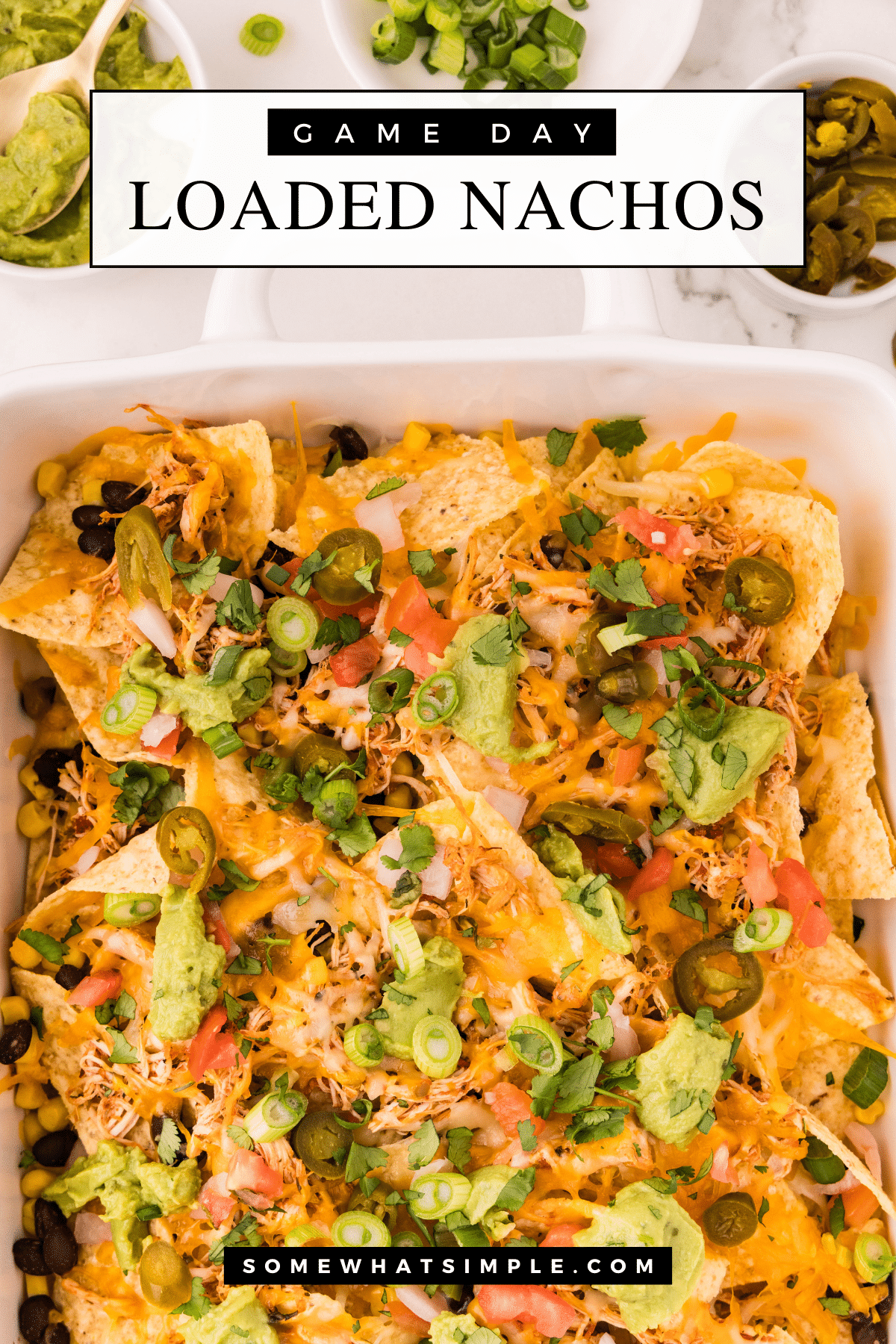 Nothing says game day like a giant pan of loaded nachos! These nachos are packed with flavor, easy to make, and perfect for feeding a crowd. Instead of traditional taco meat, we're using crock pot shredded chicken for a juicy, flavorful twist. via @somewhatsimple