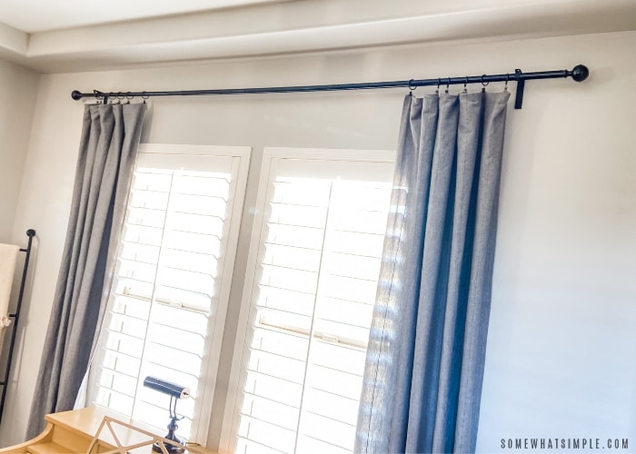 blue drapes hanging next to a window with shutters