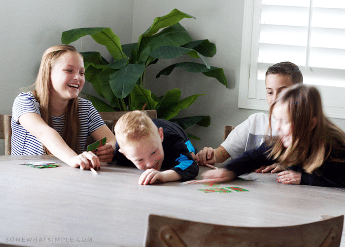 four children sitting at a table learning how to play spoons