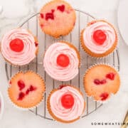 frosted cherry cupcakes on a wire baking rack