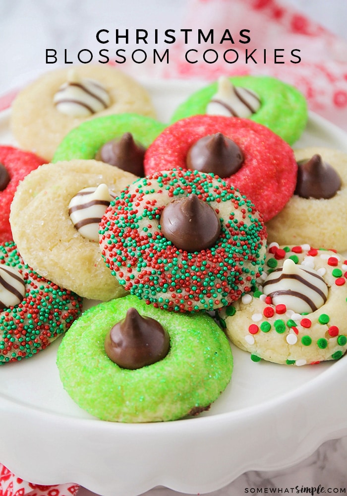 These Christmas blossom cookies are a fun and delicious way to spread some holiday cheer!  Made with your favorite sugar cookie dough, Christmas decorations and a Hershey's Kiss, these cookies are irresistible! These are so easy, they take only minutes to prepare but look like you've been baking all day! via @somewhatsimple