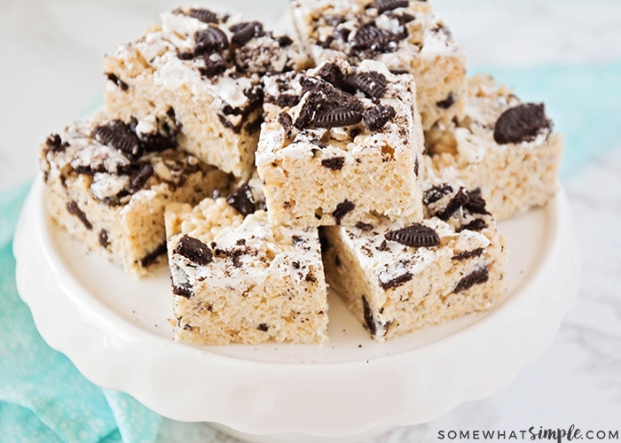 a white cake stand filled with Oreo Rice Krispie treats stacked on top.