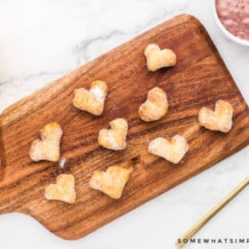 mini heart shaped donuts on a wood cutting board