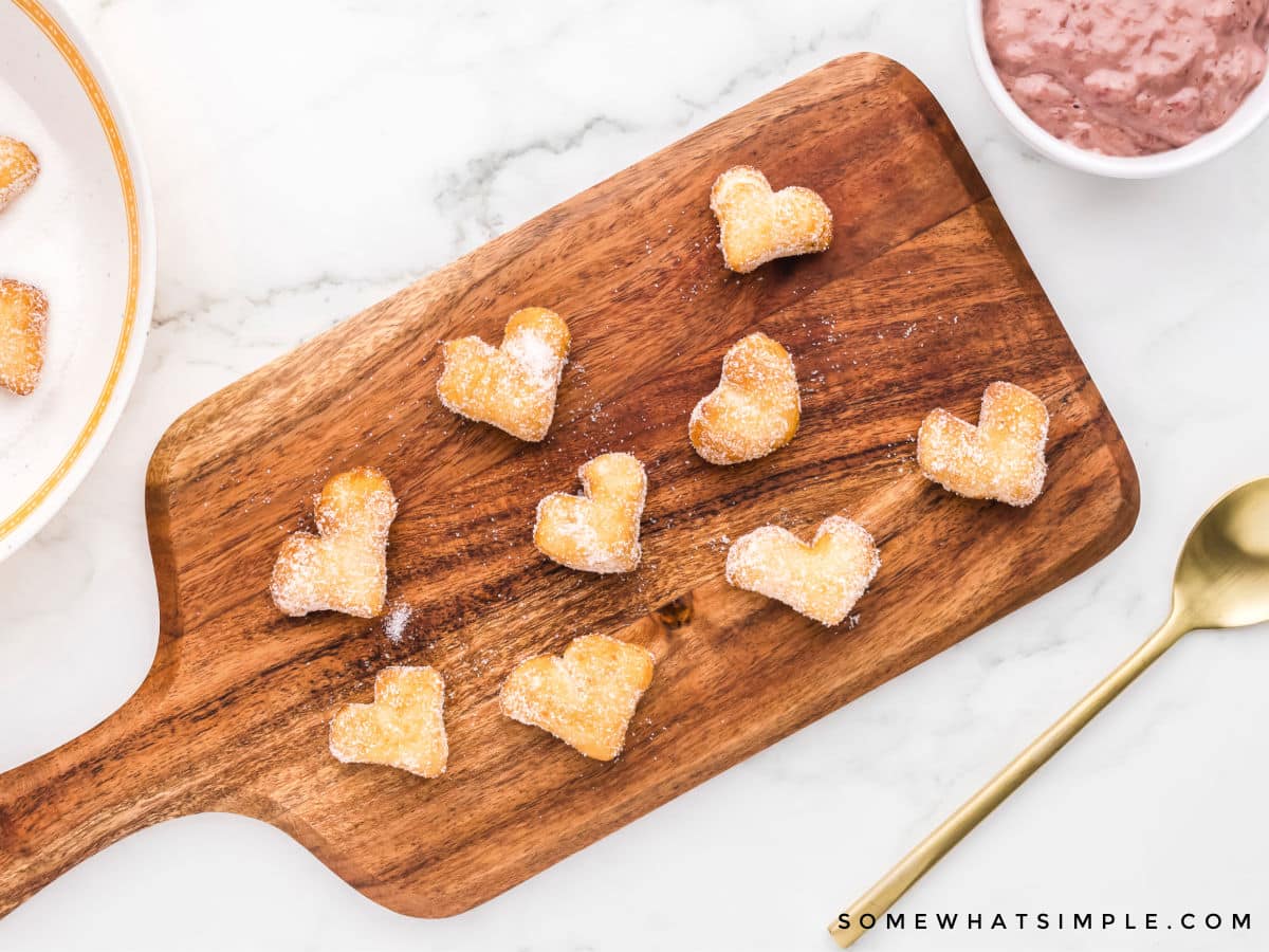mini heart shaped donuts on a wood cutting board