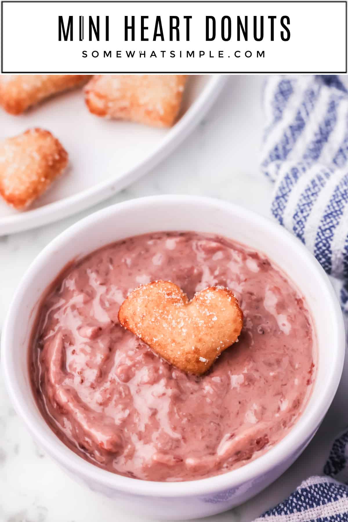 These adorable mini heart donuts are served with a sweet strawberry sauce that's perfect for Valentine's Day or any special occasion! via @somewhatsimple