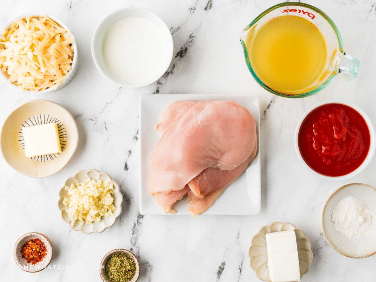 Ingredients to make Cheesy Chicken Tomato Pasta on a white counter