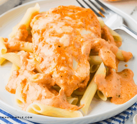 plated Cheesy Chicken Tomato Pasta with a fork and striped napkin