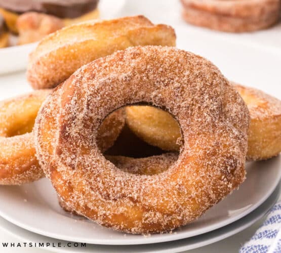 finished spudnuts with cinnamon sugar on a white plate