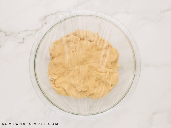 covered donut dough in a glass bowl