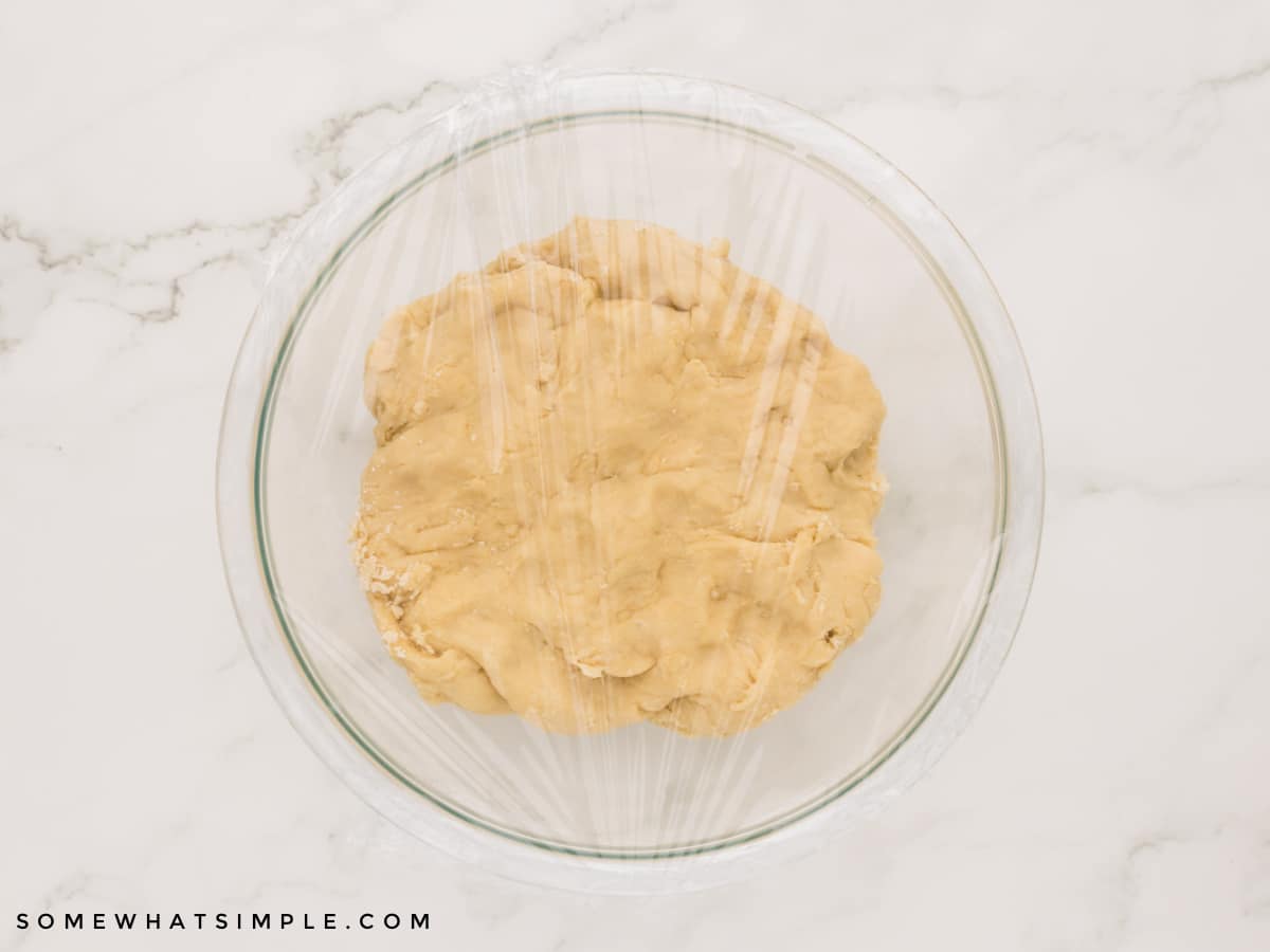 covered donut dough in a glass bowl