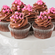 Chocolate fudge cupcakes on a white cake stand
