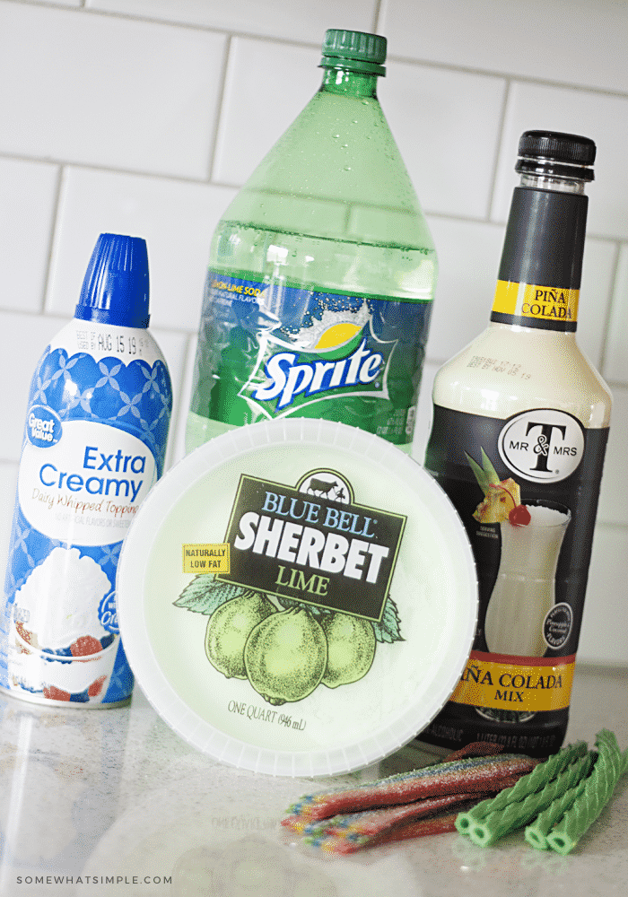 the ingredients to make a shamrock float; a bottle of sprite, a can of whipped cream, lime sherbet, pina colada mix and green licorice