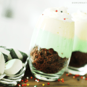 two pistachio parfait cups made with pistachio and vanilla pudding and brownie crumbles are a fun way to celebrate St Patrick's Day