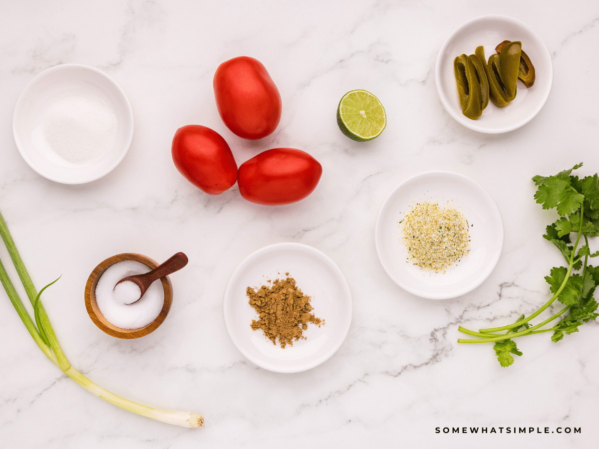 Ingredients needed to make Mild Salsa laid out on a white counter