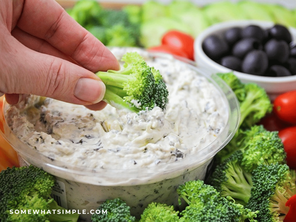 dipping a broccoli floret into ranch dressing dip