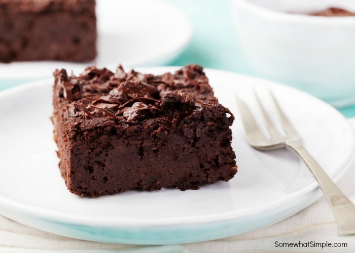 the best brownies on a white plate with fork