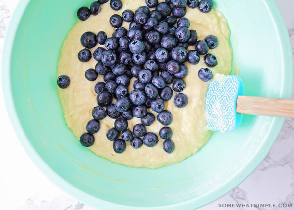 fresh blueberries being added to muffin batter