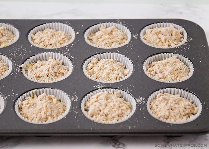 adding crumb topping to blueberry muffin batter