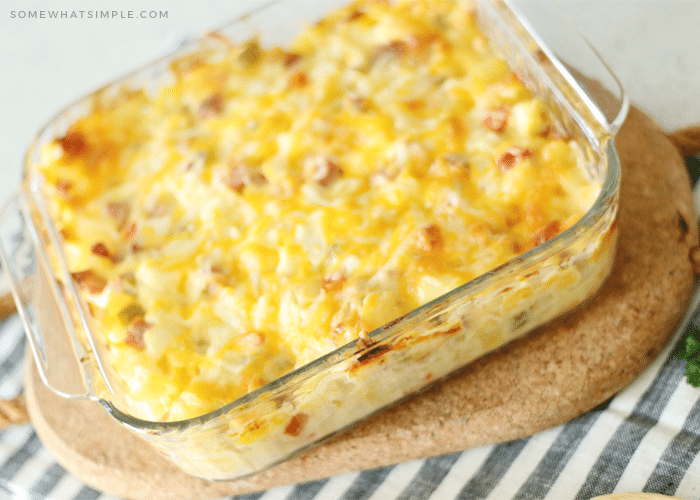 a square casserole dish filled with baked potato and ham casserole that is fresh out of the oven and the top of the casserole is a golden brown