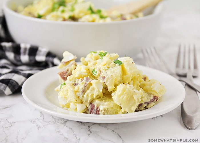 a plate with a serving of potato salad made with mustard and hard boiled eggs.