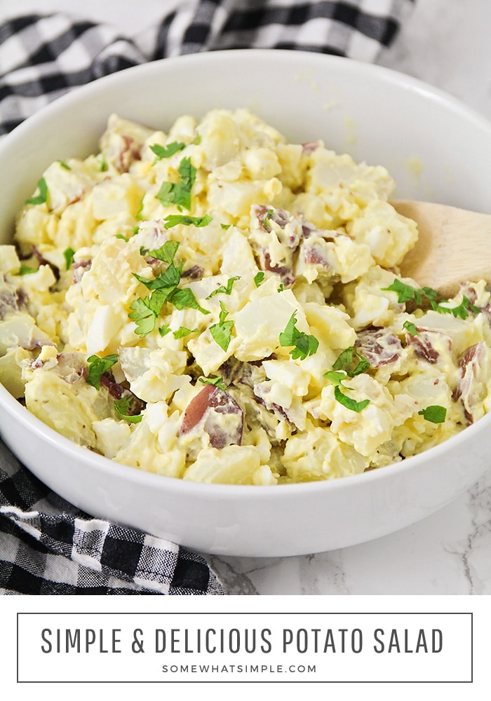 looking down into a bowl filled with a potato salad recipe made with mustard, red potatoes and hard boiled eggs. At the bottom of the image the words simple & delicious potato salad are written.