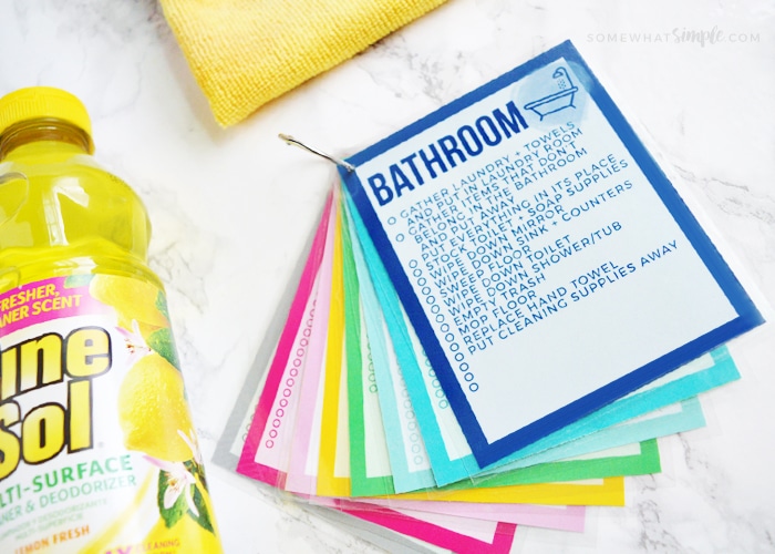 printable cleaning cards next to cleaning supplies