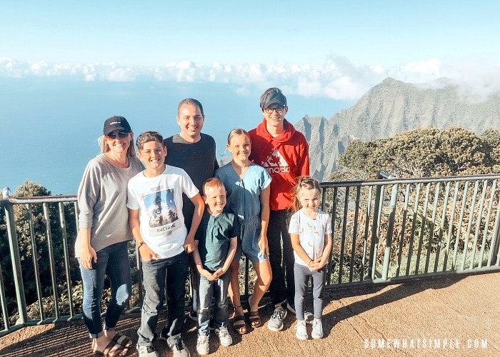 a good looking family of seven standing by a fence overlooking the Kalalau Valley and the ocean