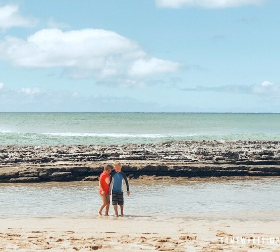 two children playing at Salt Pond beach in Kauai Hawaii