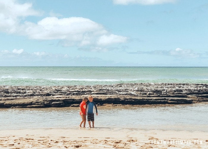 two children playing at Salt Pond beach in Kauai Hawaii