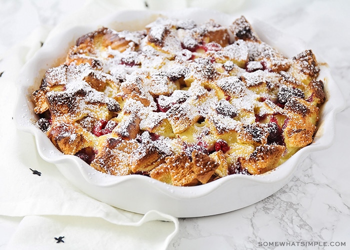 a baking dish with filled with this easy baked raspberry french toast recipe topped with powdered sugar