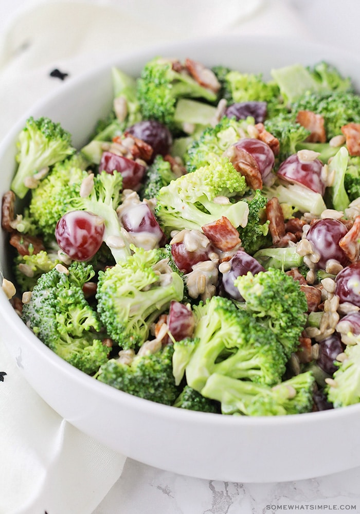 long image of a broccoli salad in a white bowl