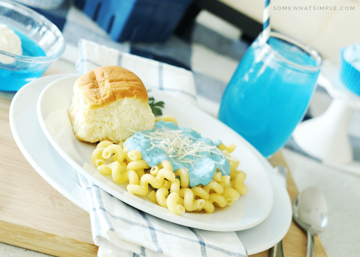 pasta with blue alfredo sauce and blue Hawaiian punch in the background