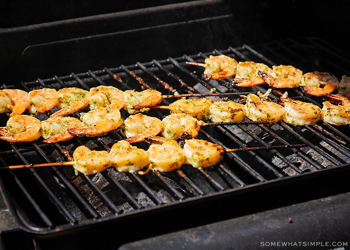 shrimp on wooden skewers being cooked on a barbecue