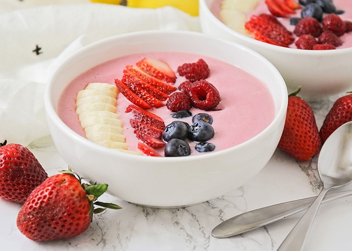 a smoothie bowl topped with sliced fresh fruit