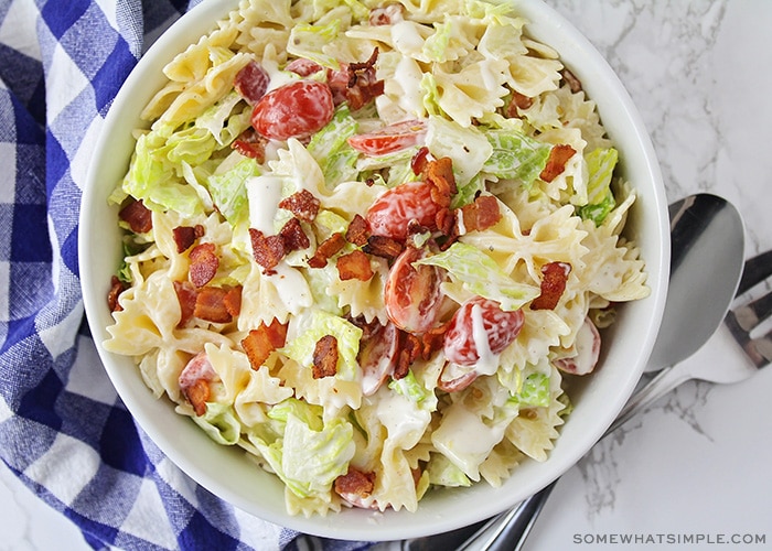 looking down on a bowl of bow tie pasta salad made with bacon, lettuce and tomatoes