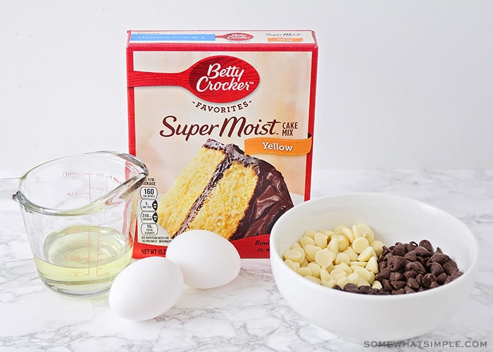 a box of betty crocker cake mix, 2 eggs, a bowl of chocolate chips and a measuring cup of oil