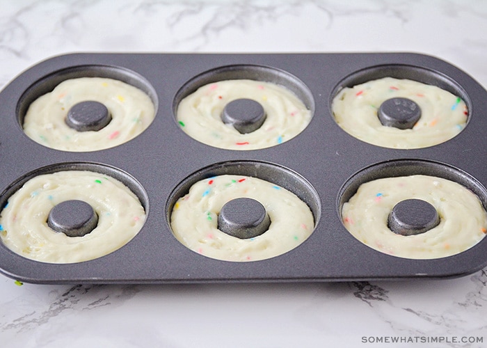 a donut pan with each slot filled with cake mix batter