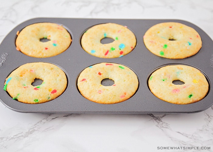 a donut pan filled with bake golden brown donuts made from cake mix