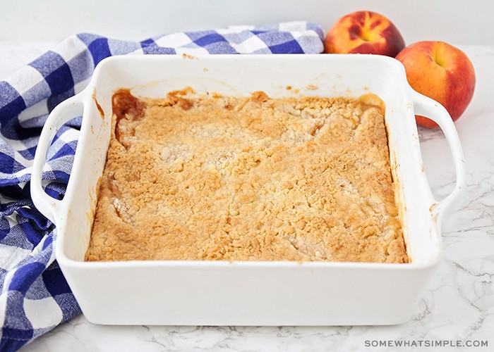 a cake mix peach cobbler that is fresh out of the oven and is golden brown on top