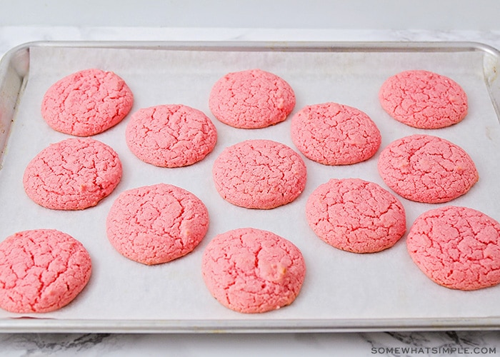 a cookie sheet filled with strawberry cookies made from cake mix fresh out of the oven