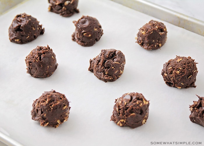 ball of raw cookie dough on a parchment paper lined cookie sheet