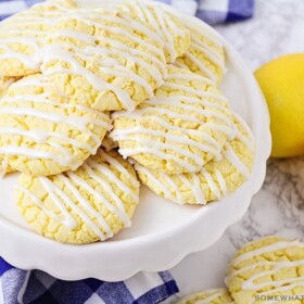 a stack of lemon cookies made from a box of cake mix with white frosting drizzled over the op