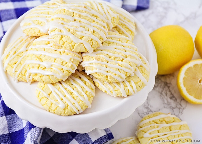 a stack of lemon cookies made from a box of cake mix with white frosting drizzled over the op