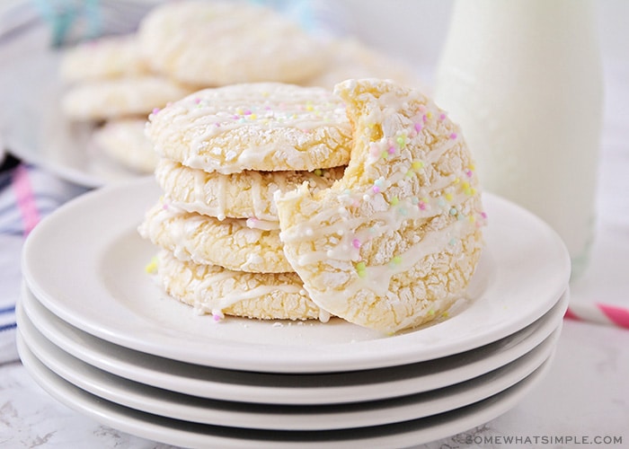 white cookies with icing drizzled on top and brightly colored sprinkles