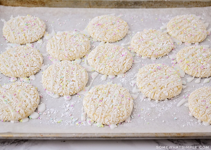 freshly baked white cookies on a cookie sheet that have just been glazed