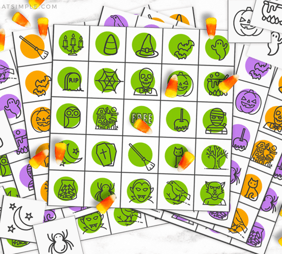 colorful Halloween bingo cards with candy corns being used as a game piece