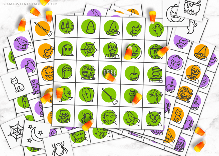 colorful Halloween bingo cards with candy corns being used as a game piece