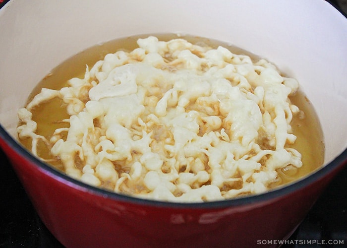 batter poured into a pot of cookie oil that is beginning to cook